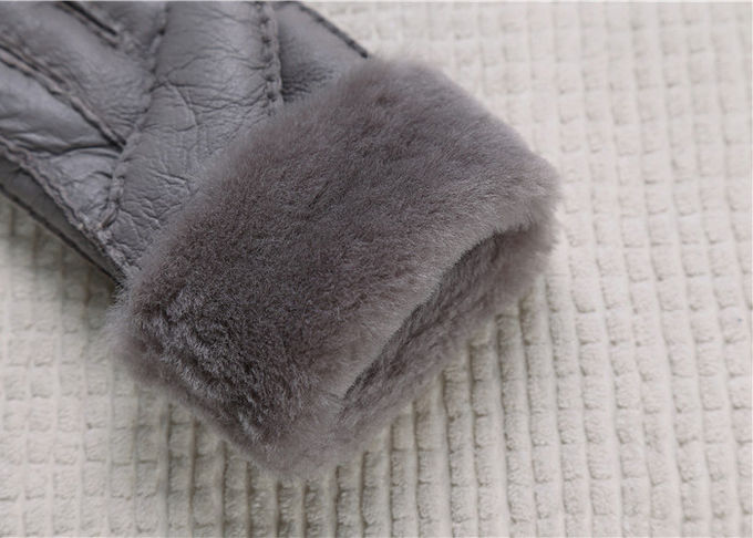 Los guantes más calientes grises alineados piel real de la zalea alisan la superficie con el finger