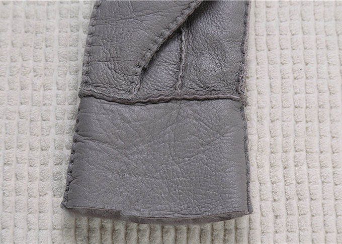 Los guantes más calientes grises alineados piel real de la zalea alisan la superficie con el finger